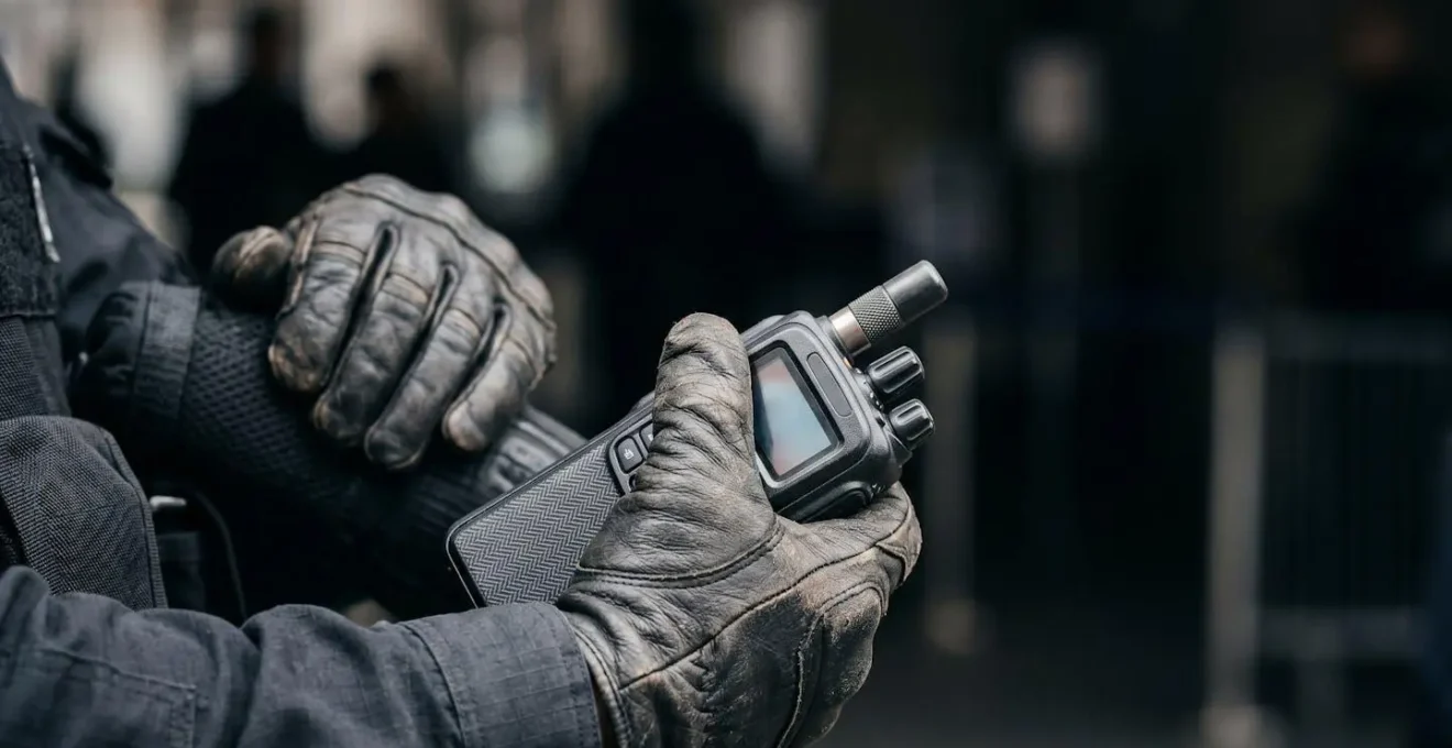 Geste professionnel d'un agent de sécurité en intervention, focus sur les mains et l'équipement de protection